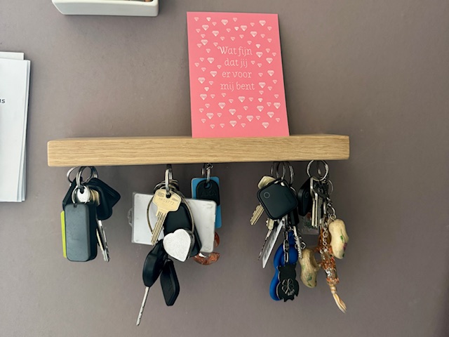 plankje met magneetjes en sleutels aan de muur